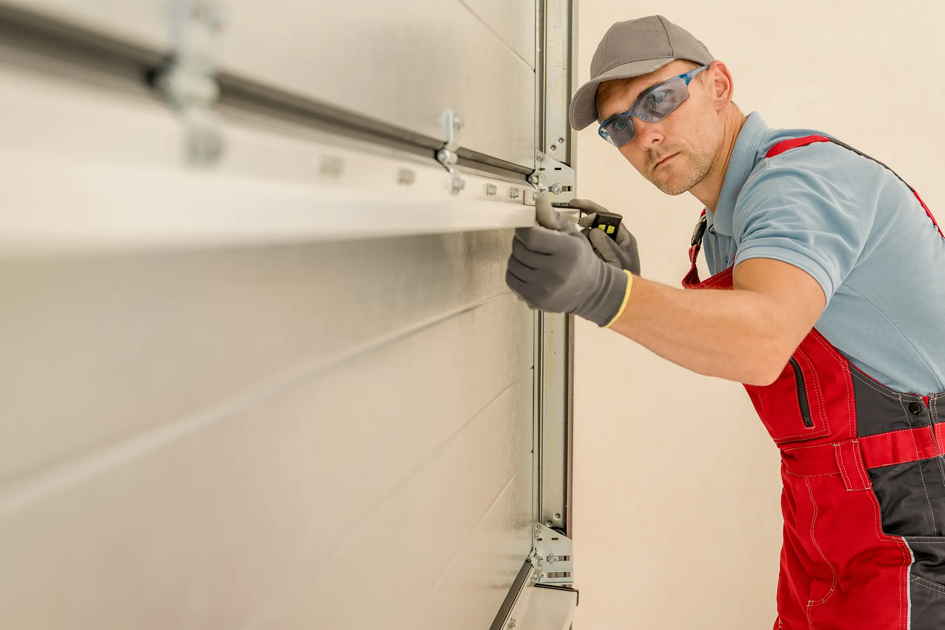 Garage door repair contractor looking down the scope of a I-beam level tool placed on a garage door.