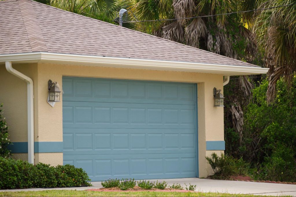A modern American house with a vast garage and double door painted green.
